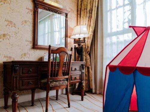 a room with a mirror and a chair and a desk at Hangzhou The First World Hotel in Hangzhou