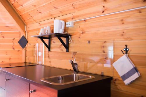 a kitchen with a sink and a wooden wall at Vestvatn - Arctic Cabins in Brekke