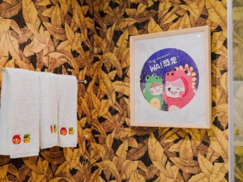 two towels and a picture on a wall at Hangzhou The First World Hotel in Hangzhou