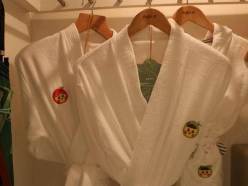 a white robe hanging on a rack with pins at Hangzhou The First World Hotel in Hangzhou