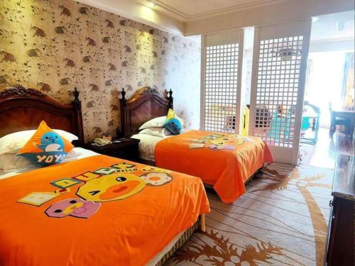 a bedroom with two beds with orange sheets at Hangzhou The First World Hotel in Hangzhou