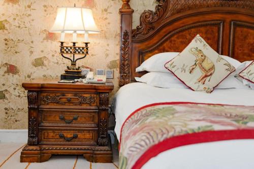 a bedroom with a bed and a night stand with a lamp at Hangzhou The First World Hotel in Hangzhou