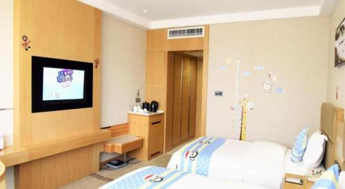 a bedroom with a bed and a flat screen tv at Changsha Huatian Hotel in Changsha