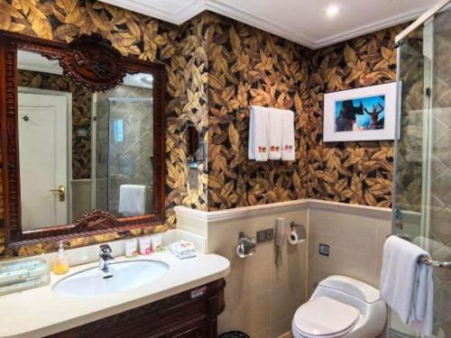 a bathroom with a sink and a toilet and a mirror at Hangzhou The First World Hotel in Hangzhou
