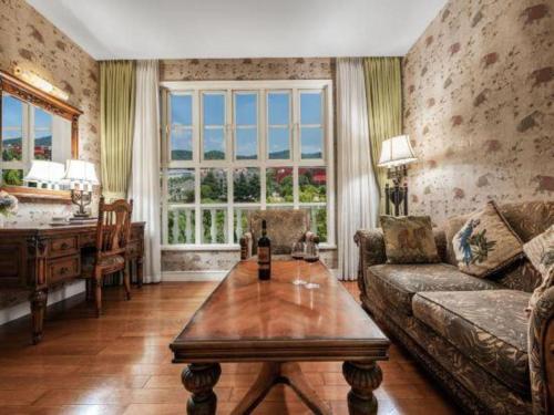 a living room with a couch and a table at Hangzhou The First World Hotel in Hangzhou