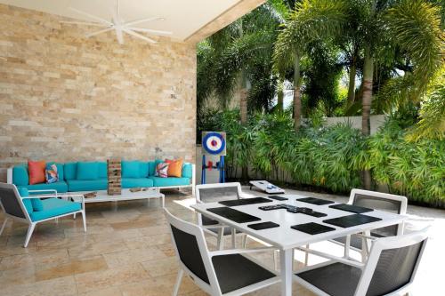 a patio with a table and chairs and palm trees at Hyatt Place San Juan in San Juan