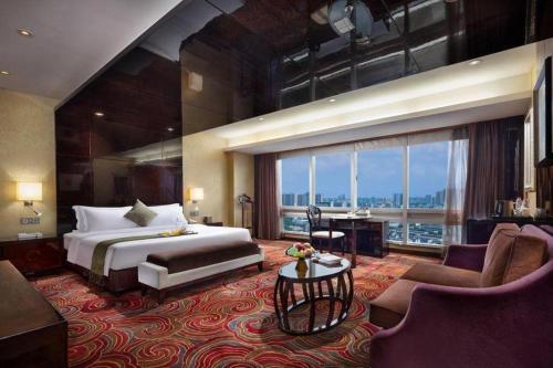 a hotel room with a bed and a large window at Changsha Huatian Hotel in Changsha