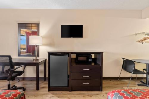 a hotel room with a desk and a tv at Econo Lodge Fredericksburg near I-95 in Fredericksburg