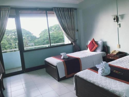 a hotel room with two beds and a large window at Vientiane Chaleunxay Center Hotel in Vientiane
