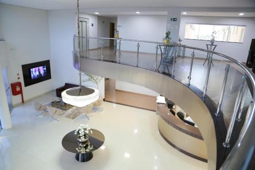 a spiral staircase in a living room with a tv at Rota Hoteis Itumbiara in Itumbiara