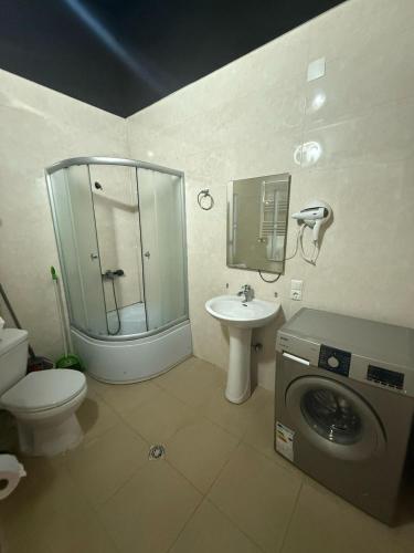 a bathroom with a shower and a sink and a washing machine at Sweet Batumi GEO in Itʼkhvisi