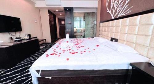 a bedroom with a large bed with red roses on it at Kunming Long Way Hotel in Kunming
