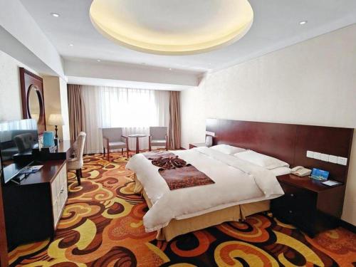 a large hotel room with a bed and a desk at Dalian Southern Airline Pearl Hotel in Dalian