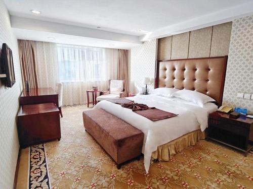 a large bedroom with a large bed and a desk at Dalian Southern Airline Pearl Hotel in Dalian