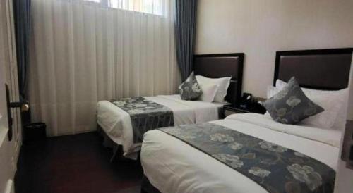 a hotel room with two beds and a window at The Century Seaview Hotel in Shenzhen