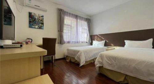 a hotel room with two beds and a desk at The Century Seaview Hotel in Shenzhen