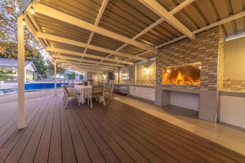 a deck with a fireplace and a table and chairs at Room 6 - LEO Sky Guest House in Simondium