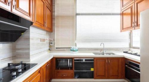 a kitchen with wooden cabinets and a sink and a window at The Century Seaview Hotel in Shenzhen