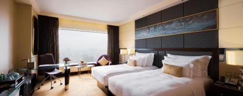 a hotel room with two beds and a desk at StarWorld Hotel in Macau