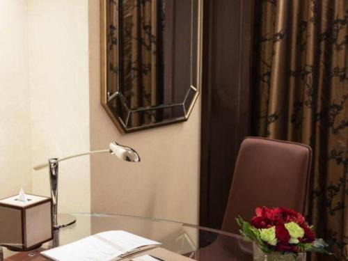 a glass desk with a lamp and a vase of flowers at StarWorld Hotel in Macau