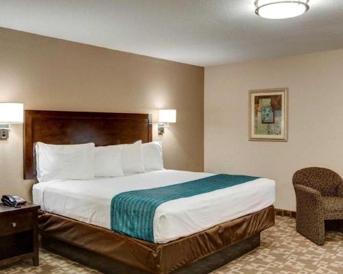 a hotel room with a large bed and a chair at Suburban Extended Stay La Place in Laplace