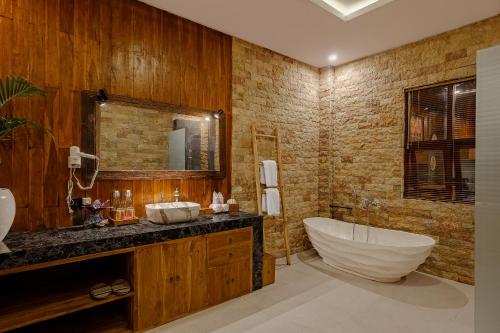 a bathroom with a tub and a sink and a bath tub at Badawa Ubud Villa in Ubud