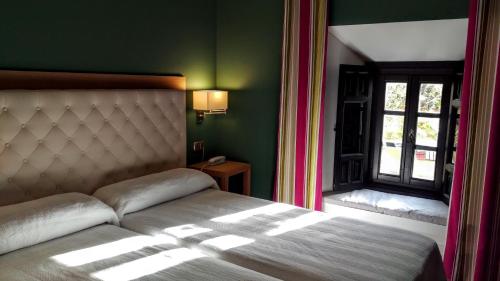 a bedroom with a bed and a window at Hospedería Santa Elena in San Carlos del Valle