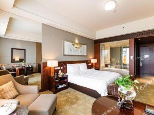 a large hotel room with a bed and a living room at Quanzhou Guest House Hotel in Quanzhou