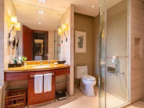 a bathroom with a toilet and a sink and a shower at Quanzhou Guest House Hotel in Quanzhou