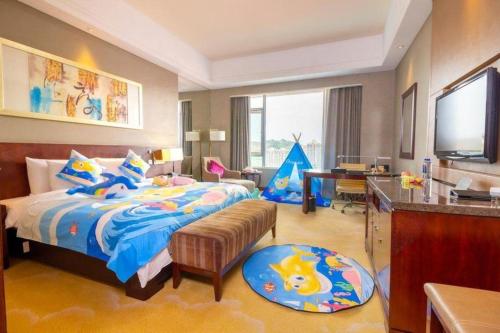 a bedroom with a bed and a desk and a television at Quanzhou Guest House Hotel in Quanzhou