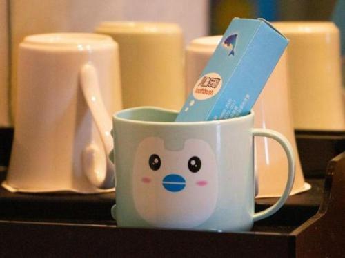 a cup with a toothbrush in it on a table at Quanzhou Guest House Hotel in Quanzhou