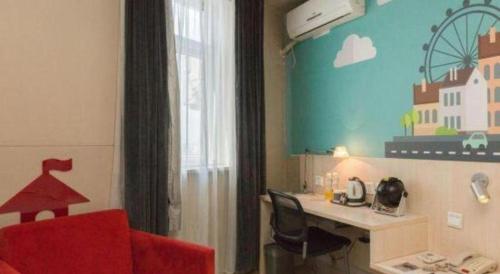 a room with a desk and a red chair at Jinjiang Inn Changchun Xi An Avenue Branch in Changchun