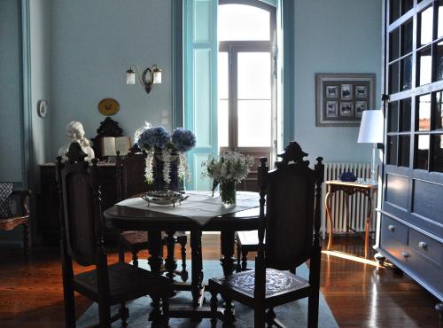 a dining room with a table and chairs and a window at Palacete Villa Idalina in Caminha