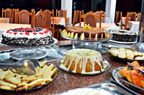 a table with different types of cakes and other desserts at Praia Sol Hotel in Santa Terezinha de Itaipu