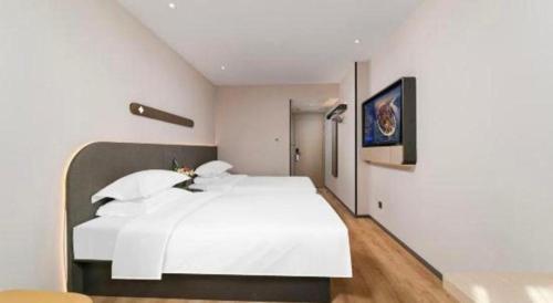 a white bedroom with a large white bed in it at Jinjiang Inn Changchun Xi An Avenue Branch in Changchun