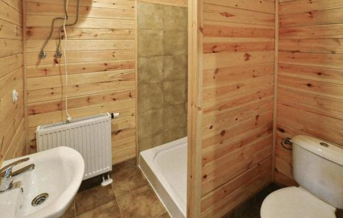 a bathroom with a tub and a toilet and a sink at Beautiful Home In Przewloka in Przewłoka
