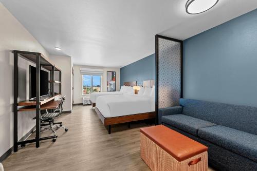 a hotel room with a bed and a couch at Everhome Suites Brownsville in Brownsville