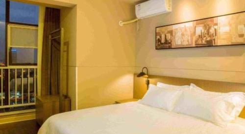 a bedroom with a white bed and a window at Jinjiang Inn Select Kunming High-speed South Railway University Town in Kunming