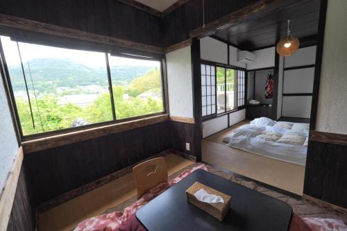 a room with a bed and a table in it at Secret Base Tokinokakera in Yufuin