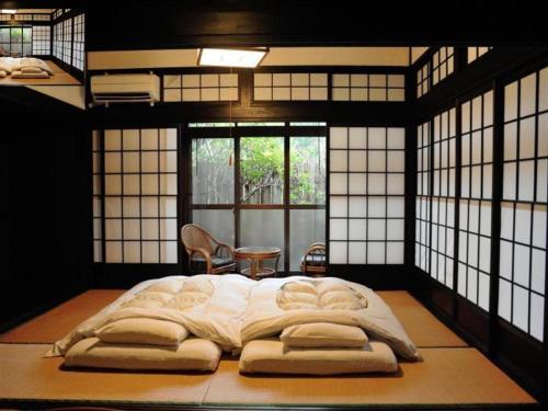 a large bed in a room with windows at Secret Base Tokinokakera in Yufuin