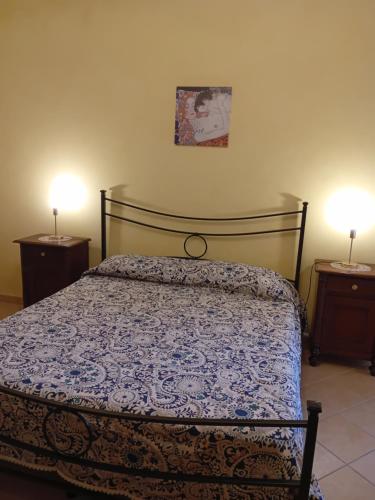 a bedroom with a bed and two night stands with lamps at A casa di Sonia in Martano