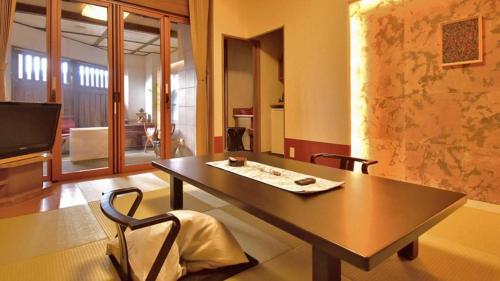 a table and chairs in a room with a television at Tsukino Sumika Atami Juraku Hotel in Atami