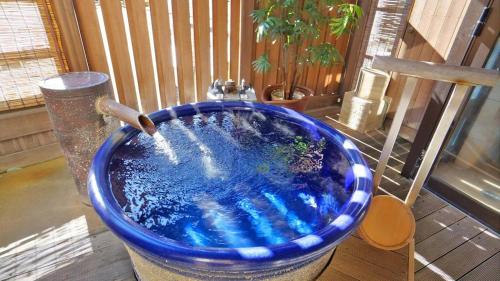 a large blue tub with a water fountain at Tsukino Sumika Atami Juraku Hotel in Atami