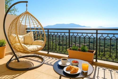 a balcony with a swing chair and a table with food at Aegean Bliss - Marathos Retreat Samos in Kámpos