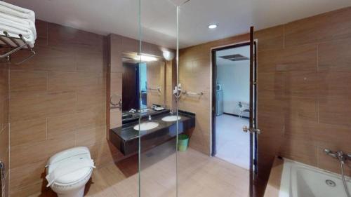 a bathroom with a toilet and a glass shower at Ritz Garden Hotel in Ipoh