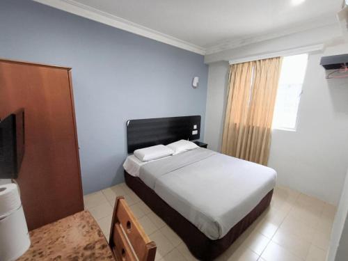 a bedroom with a bed and a television in it at Sherrinton Hotel in Mentekab