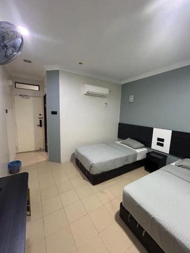 a hotel room with two beds and a bathroom at Sherrinton Hotel in Mentekab