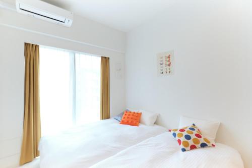 a bedroom with a white bed with a window at Cure Skytree in Tokyo