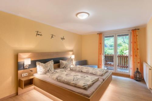 EimelrodにあるFerienwohnungen Wilke Mühleのベッドと大きな窓のある寝室