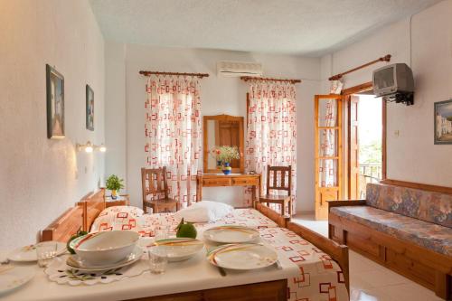 a room with a table, chairs, and a window at Sofia's Garden Studios in Skopelos Town